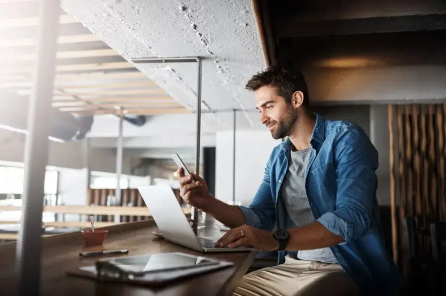 Guy reading an article on his phone on overcoming common challenges of implementing entreprise mobility