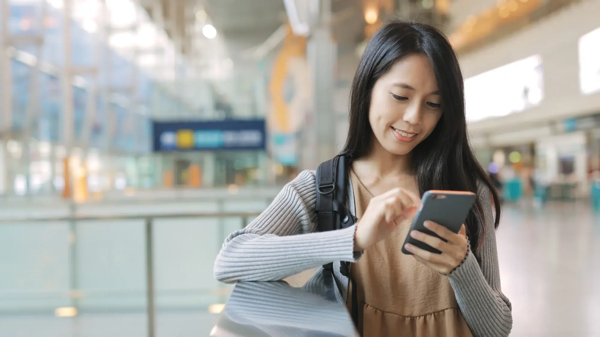 Woman after communicating on her phone across the border is checking telecom costs